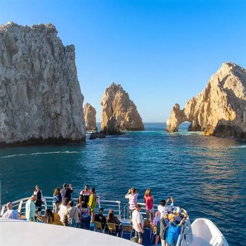 Туристы фотографируют арку Лос-Кабос с туристического катера в Лос-Кабосе, Южная Нижняя Калифорния, Мексика