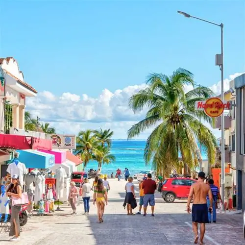 Туристы, прогуливающиеся по улице, ведущей к Карибскому морю в Канкуне, Кинтана-Роо, Мексика