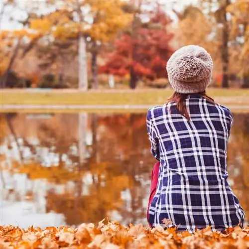 Женщина рядом с озером осенью