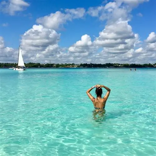 Женщина в лагуне семи цветов озера Бакалар в Мексике