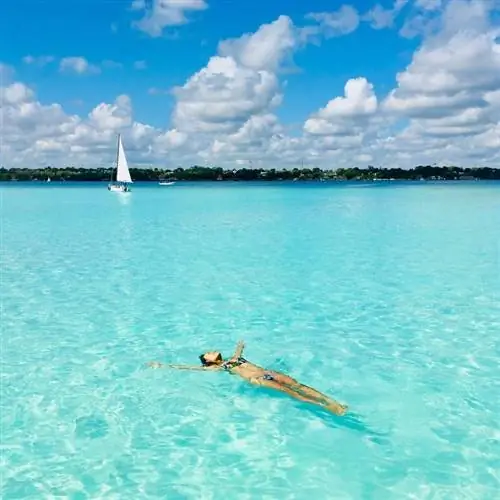 Молодая женщина лежит на спине в лагуне Бакалар, Бакалар, Мексика
