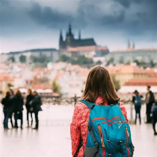 Молодая женщина-туристка смотрит на Верхний город на заднем плане, Прага