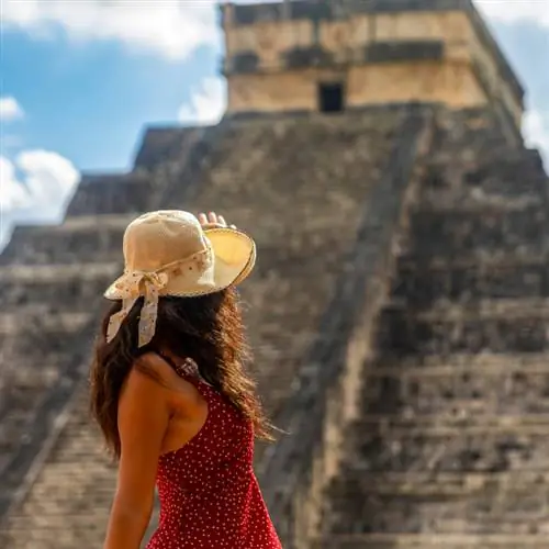 Женщина смотрит на пирамиду в Мексике