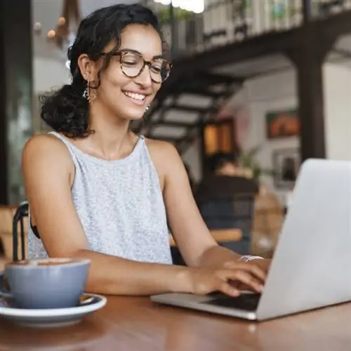 Женщина за компьютером работает в кафе, местонахождение не указано