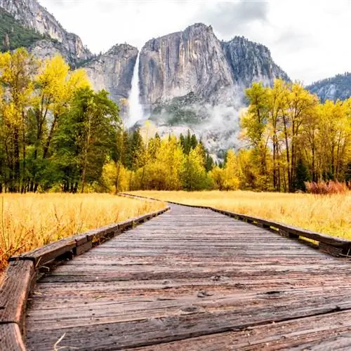 Луг с променадом в долине Йосемитского национального парка с Йосемитским водопадом пасмурным осенним утром