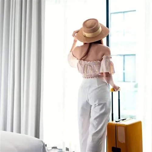 женщина стоит в отеле с чемоданом