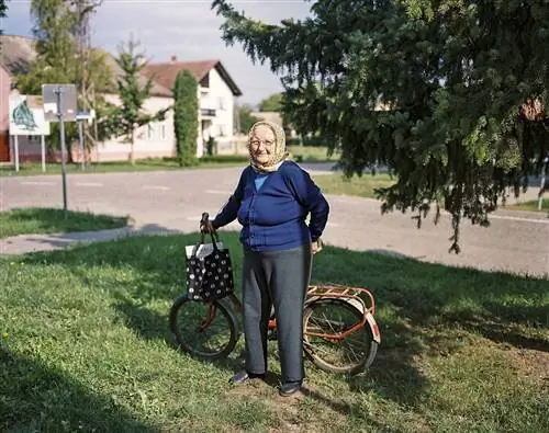 Женщина едет на велосипеде через деревню по Тропе мира.