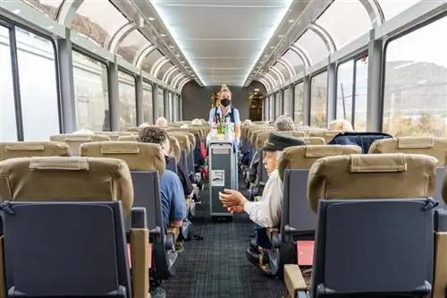 В вагонах поезда есть большие арочные окна, из которых открывается панорамный вид на проносящиеся мимо пейзажи.