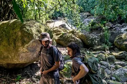 Биологи Earthwatch Маноэль Муанис и Джулиан Уиллмер идут по тропе в заповеднике, чтобы проверить ловушки для животных.