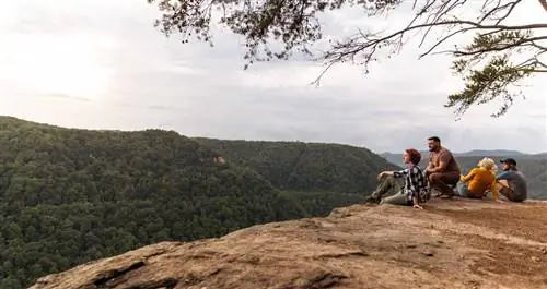 Семья смотрит на долину с вершины хребта.
