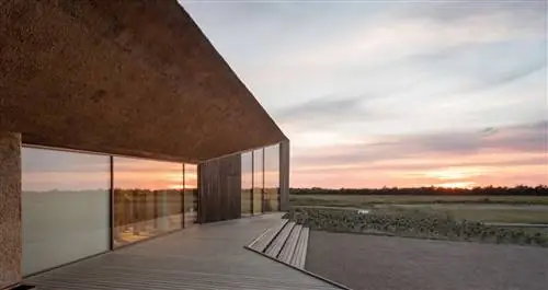 Современный особняк на плоской равнине на закате.