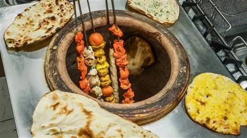 Мясо на вертеле сидит прямо на пламени в печи тандыр.