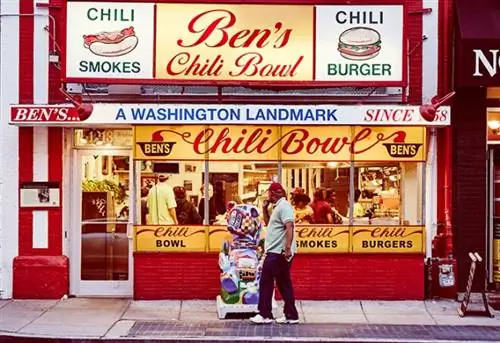 Мужчина проходит мимо чаши Ben's Chili Bowl