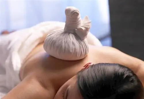 Женщина получает массаж с компрессом