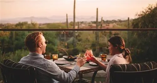 Пара коктейлей на балконе с видом на пустыню на закате.
