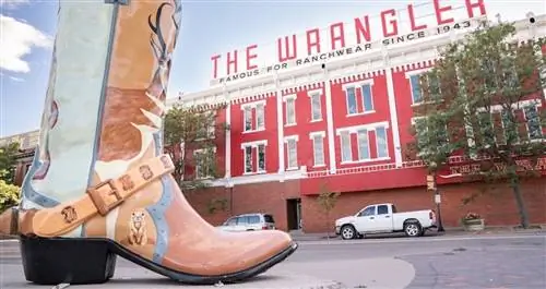 ШАЙЕНН, Вайоминг - 27 апреля 2018 года: Знак на вершине Wrangler в историческом центре города Шайенн, штат Вайоминг. Трехэтажное кирпичное здание красного цвета возвышается на углу Капитолийской авеню и Линкольн-уэй.