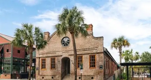 Исторический склад из красного кирпича на улице с пальмами