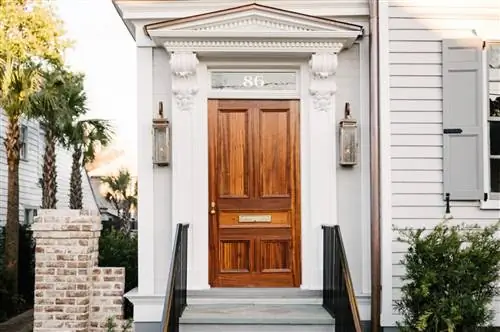 Коричневая входная дверь 86 Cannon Inn, белого здания.