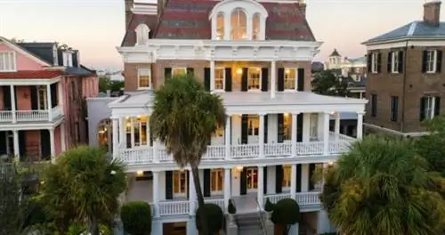 Трехэтажное здание с закругленными белыми галереями.