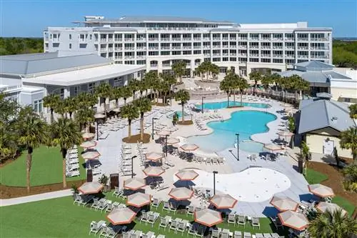 Большие изогнутые бассейны в окружении шезлонгов отеля Sweetgrass Inn.