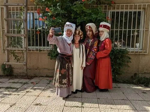 Айдай Асангулова и ее семья позируют для селфи в традиционных кыргызских костюмах.