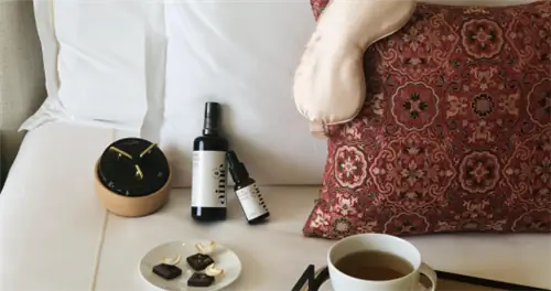 Музыкальная шкатулка, шоколад, капельки мелатонина, чай и маска для глаз на кровати.