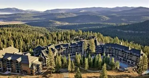 Вид сверху на отель Ritz-Carlton, озеро Тахо в окружении вечнозеленых растений.