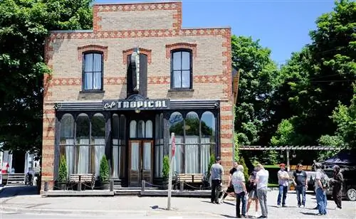 Café Tropical - одно из вымышленных мест, по которым посетители могут пройти на выставке. Мы надеемся, что они также смогут просмотреть копию печально известного слишком длинного меню.
