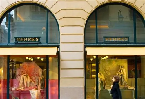 Женщина, проходящая мимо магазина Hermes на улице Сент-Оноре, Париж, Франция