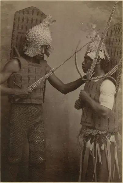 Двое мужчин в шлемах из рыбы-дикобраза, доспехах из кокосового волокна и таумангарии