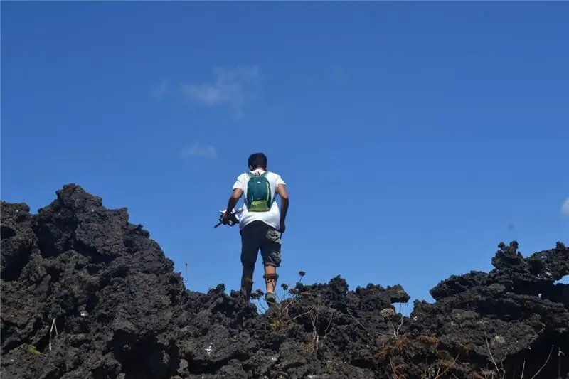 Д'Эмануэле систематически перемещается по каменистой местности от одного гнезда буревестника к другому с блокнотом и самодельным корко в руке