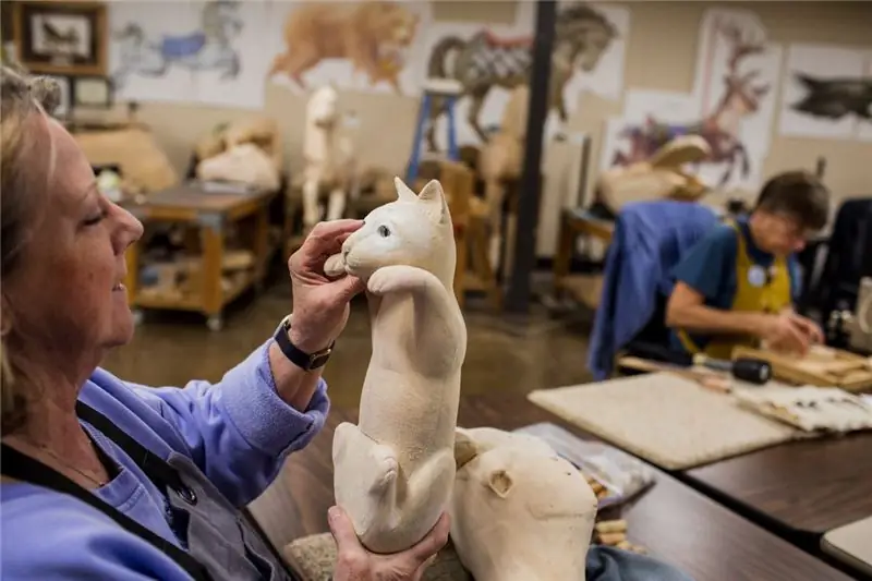 Волонтер Нона Тилтон работает над проектом резьбы в карусели в Олбани