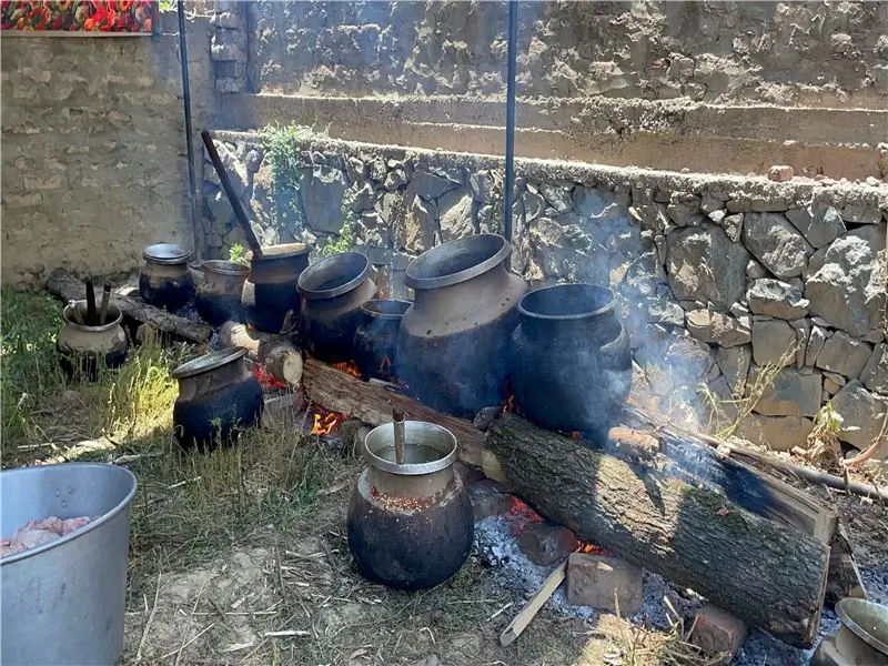 Классическая импровизированная кухня ваза состоит из длинных деревянных бревен, уложенных параллельно друг другу, чтобы удерживать их гигантские медные горшки