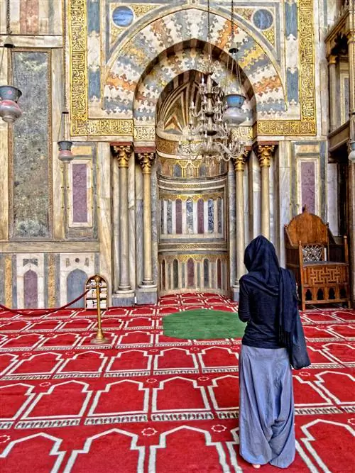 Женщина стоит перед михрабом мечети Султана Хасана в Каире, Египет