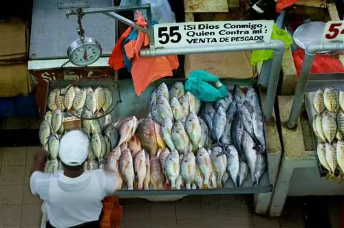 Продавец устраивает выставку рыбы в торговом центре Mercardo del Mariscos в районе Каско-Вьехо в Панама-Сити.