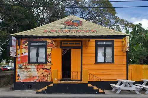Магазин рома BAR3AY в Бриджтауне, округ Сент-Майкл, Барбадос - ярко-оранжевое небольшое деревянное здание. Магазин рома BAR3AY в Бриджтауне, округ Сент-Майкл, Барбадос - ярко-оранжевое небольшое деревянное здание.
