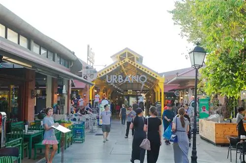 Люди и рестораны в Asiatique, набережной с ресторанами на реке Чао Прайя в Бангкоке. Люди ходят между ресторанами, слева стоит официантка, а на заднем плане фуд-корт и торговая зона. Люди и рестораны в Asiatique, набережной с ресторанами на реке Чао Прайя в Бангкоке. Люди ходят между ресторанами, слева стоит официантка, а на заднем плане фуд-корт и торговая зона.