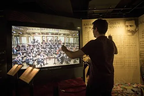 Человек дирижирует виртуальным оркестром в Haus der Musik в Вене. Человек дирижирует виртуальным оркестром в Haus der Musik в Вене.