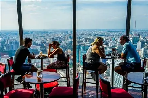 Клиенты сидят у окна в кафе EON, откуда открывается вид на Хошимин внизу.