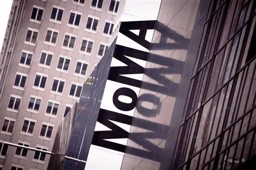 Буквы MOMA отражаются в окнах музея в Нью-Йорке.