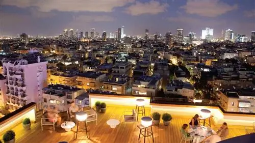 Люди сидят за столами в ресторане Blue Sky на крыше отеля Carlton Tel Aviv.