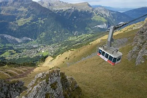Канатная дорога свисает высоко над долиной Лаутербруннен в Швейцарии.
