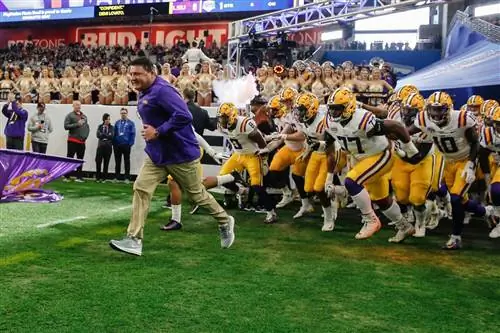 Главный тренер LSU Tigers Эд Оргерон выводит свою команду на футбольное поле перед игрой LSU; однодневные поездки Новый Орлеан