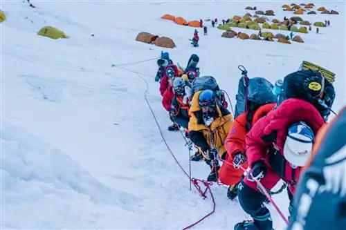 Члены команды Full Circle Everest в очереди альпинистов, поднимающихся на гору, на фоне одного из лагерей.