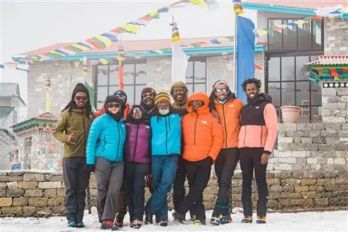 Команда Full Circle Everest позирует на улице в снежный день во время тренировочной поездки в Непал.
