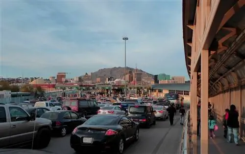 Несколько рядов автомобилей стоят неподвижно, когда люди проходят через порт въезда на границе США и Мексики в Эль-Пасо, штат Техас.