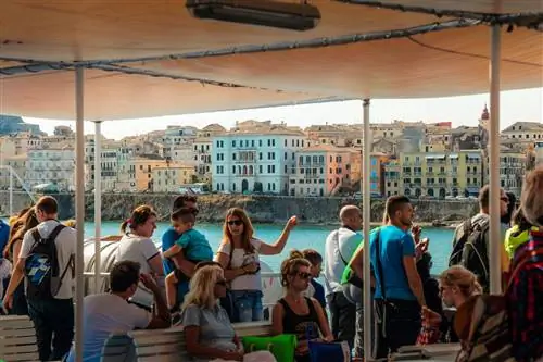 Туристы на пароме, прибывающем в Корфу, Греция.