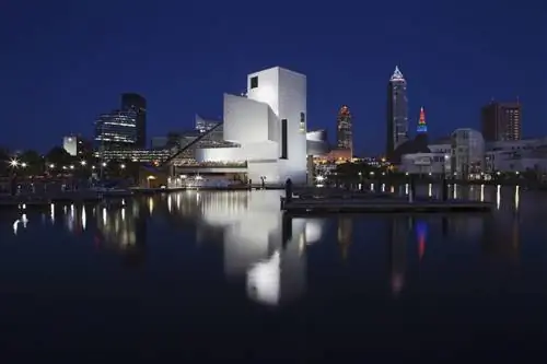 белая структура прямоугольников, треугольников и цилиндров светится на фоне темного неба