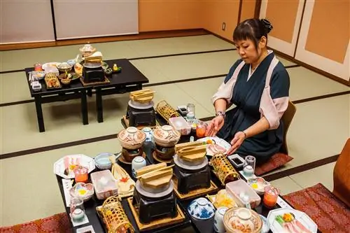 Официантка подает традиционную еду в рёкане Fujiya в Каваю-Онсэн на Кумано-Кодо.