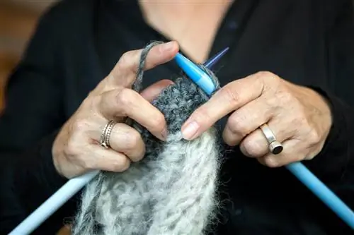 Женщина вяжет свитер из фарерской шерсти.